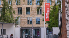 Eine Fahne mit der Aufschrift 'BDEW Kongress' weht am Eingang zur STATION-Berlin