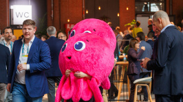 Zwei Maskottchen in Form eines Oktopus laufen durch die Ausstellung des BDEW Kongress 2025