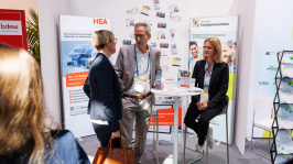 Menschen unterhalten sich an einem Ausstellungsstand