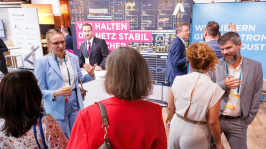 Menschen unterhalten sich an einem Ausstellungsstand