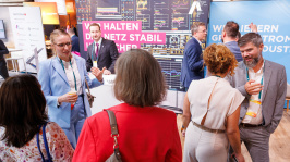 Menschen unterhalten sich an einem Ausstellungsstand