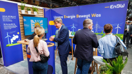 Menschen unterhalten sich an einem Ausstellungsstand