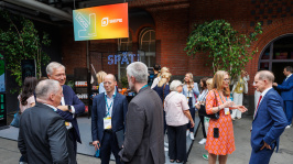 Menschen unterhalten sich vor einem Ausstellungsstand