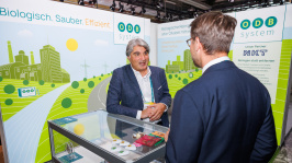 Menschen unterhalten sich an einem Ausstellungsstand