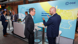 Menschen unterhalten sich an einem Ausstellungsstand