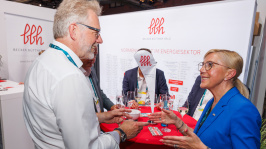 Menschen unterhalten sich an einem Ausstellungsstand