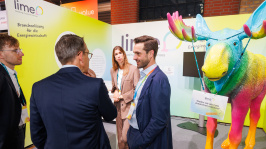 Menschen unterhalten sich an einem Ausstellungsstand
