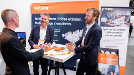 Menschen unterhalten sich an einem Ausstellungsstand