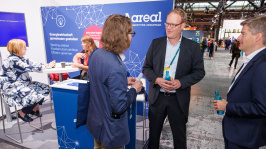 Menschen unterhalten sich an einem Ausstellungsstand