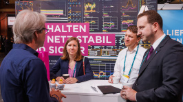 Menschen unterhalten sich an einem Ausstellungsstand