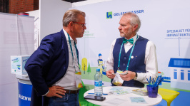 Menschen unterhalten sich an einem Ausstellungsstand