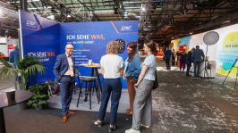Menschen unterhalten sich an einem Ausstellungsstand