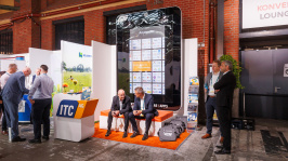 Menschen unterhalten sich an einem Ausstellungsstand