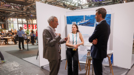 Menschen unterhalten sich an einem Ausstellungsstand