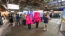 Zwei Maskottchen in Form eines Oktopus laufen durch die Ausstellung des BDEW Kongress 2025