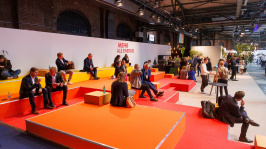 Menschen sitzen auf einem Podest in den Farben des BDEW Kongress 2025