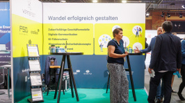 Menschen unterhalten sich an einem Ausstellungsstand