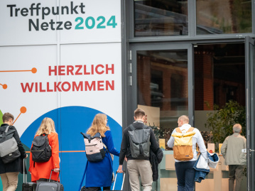Menschen gehen durch die Eingangstür der STATION-Berlin