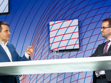 Leonhard Birnbaum diskutiert mit Klaus Müller auf der Plenumsbühne des BDEW Kongress 2022