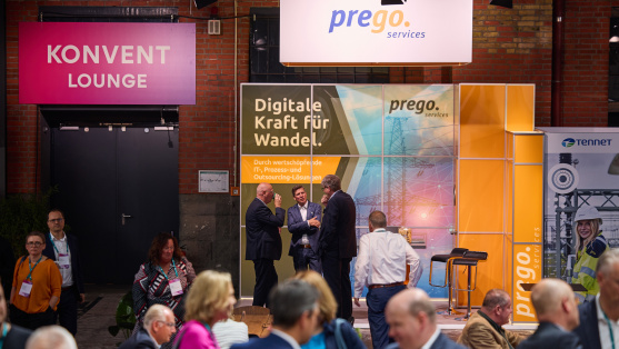 Menschen unterhalten sich an einem Ausstellungsstand