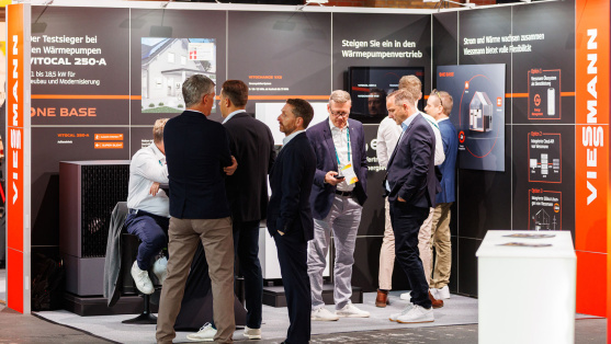 Menschen unterhalten sich an einem Ausstellungsstand