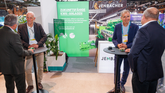 Menschen unterhalten sich an einem Ausstellungsstand