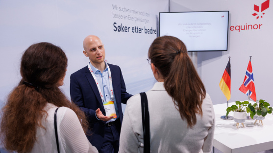 Menschen unterhalten sich an einem Ausstellungsstand