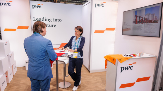 Menschen unterhalten sich an einem Ausstellungsstand