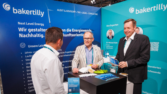 Menschen unterhalten sich an einem Ausstellungsstand