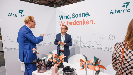 Menschen unterhalten sich an einem Ausstellungsstand