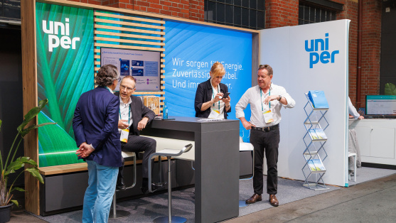 Menschen unterhalten sich an einem Ausstellungsstand