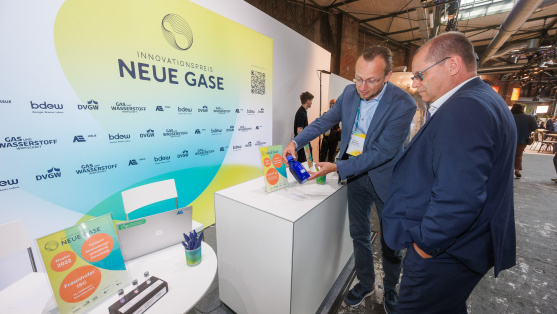 Menschen unterhalten sich an einem Ausstellungsstand