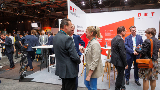 Menschen unterhalten sich an einem Ausstellungsstand