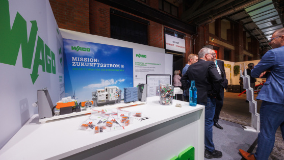 Menschen unterhalten sich an einem Ausstellungsstand