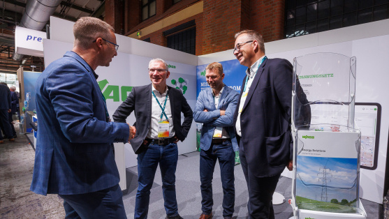 Menschen unterhalten sich an einem Ausstellungsstand